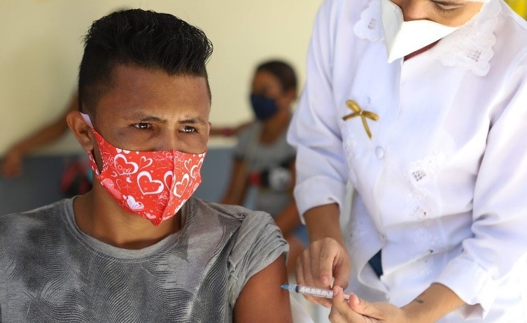 masked man receives vaccine