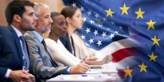 Generic image showing group meeting with US and EU flags in background