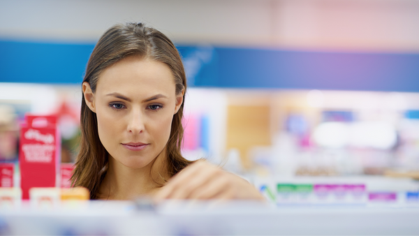 Woman looking at products on a pharmacy shelf.