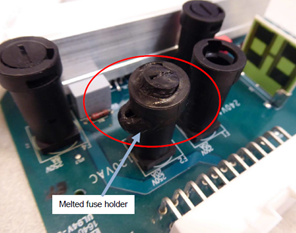 A close-up of a circuit board. The red circle and blue arrow indicate which fuse holder has melted.