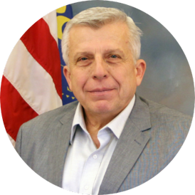 Headshot of man in front of American Flag