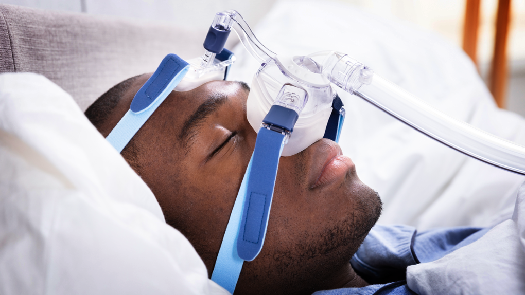 MAN SLEEPING CPAP MACHINE