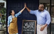 a woman and a man high-fiving each other in front of a restaurant