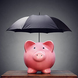 pink piggy bank under a black umbrella