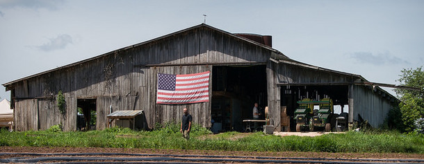 U.S. Marine Corps veteran Calvin Riggleman stands in front of a U.S. flag displayed on a barn on Bigg Riggs farm in Hampshire County, WV.