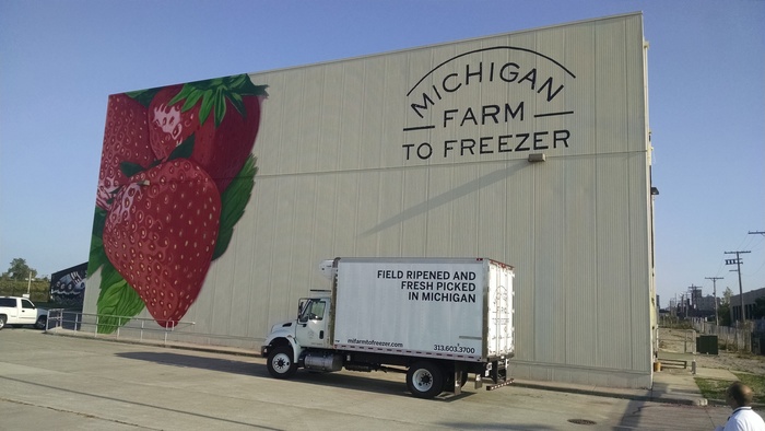 A delivery truck is parked in front of the Michigan Farm to Freezer warehouse. 