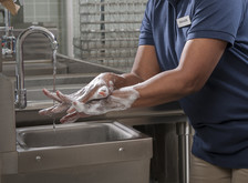 close up photo of a school nutrition professional washing hands with soapy water