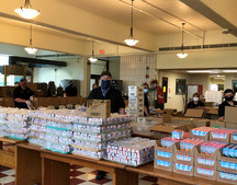School Nutrition Professionals standing behind bulk quantities of school meal items