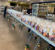 School Nutrition Professionals standing with hundreds of packaged school meals