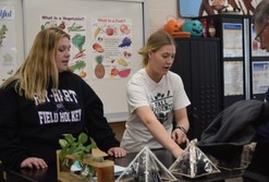 Two teen aged girls giving a gardening demonstration 