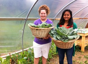 Two girls holding baskets of greens