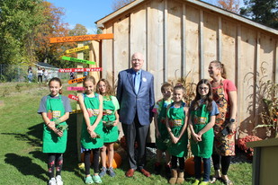 Senator Patrick Leahy posing with children at an outdoor garden 