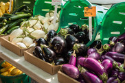 Various types of eggplants for sale at a market.