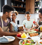 Black family cooking a healthy meal in modern kitchen