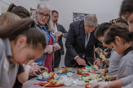 USDA Secretary Vilsack cutting vegetables with elementary students 
