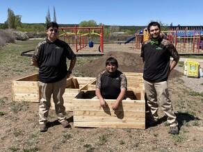 Students standing near the wooden garden boxes they built