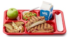 A school lunch tray with a green apple, roasted potato wedges, grilled turkey sandwich, bean salad, and milk 