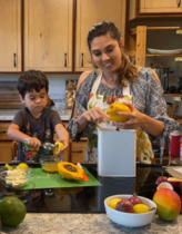Adult and child cooking in kitchen with fruit