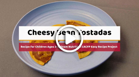 Cheesy Bean Tostada recipe video with white play button overlay