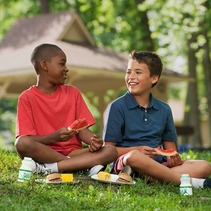 Two children eating lunch in a park 
