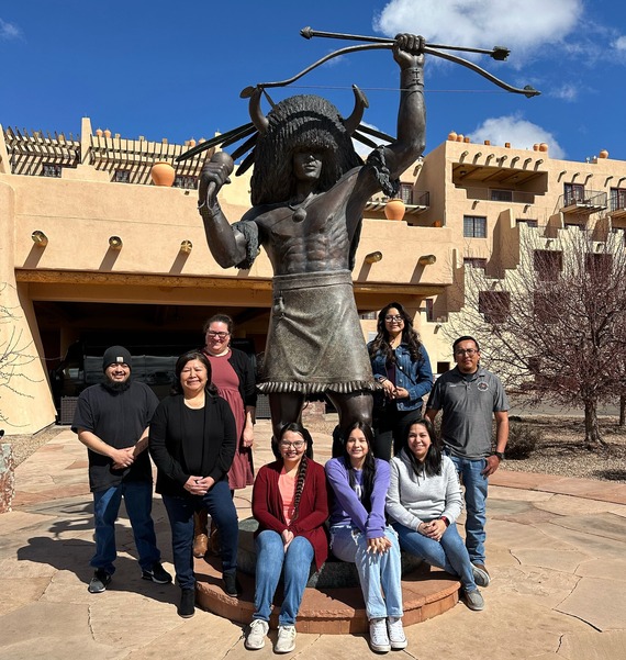 Santa Fe Champions standing in front of statue of a Native American man holding a bow and arrow