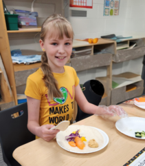 Girls cutting up vegetables in the classroom