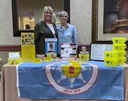 Two women standing behind the Standing Rock table