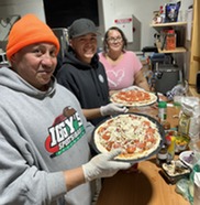 Tribal members standing with pizzas they made