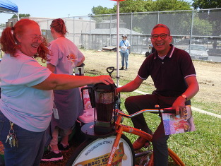 Man on bicycle that powers blender for smoothie.