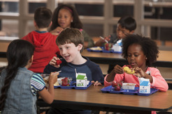 kids eating school meals at a cafeteria table