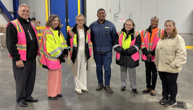 Dr. Eblen and others standing in a row inside, most wearing bright colored safety vests