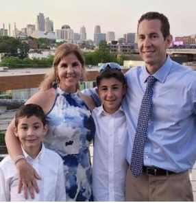 Mike Amador with wife and two children with KC skyline in the background