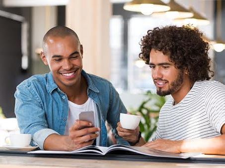 two men chatting and sharing something on their phones