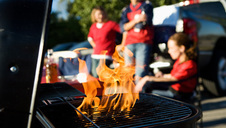 Flames on a grill at a tailgate party