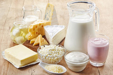 Pitcher of milk, plate of cheeses and other dairy products on a table