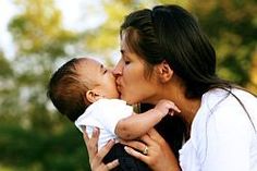photo of a woman kissing her infant child