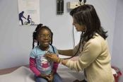 photo of a doctor examining a child with a stethoscope