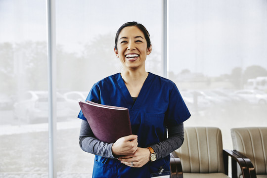 Nurse laughing with notebook