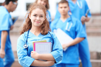 Female nursing student smiling while holding books