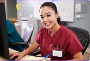 A nurse wearing red scrubs sitting at a desk