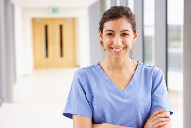 A nurse wearing light blue scrubs