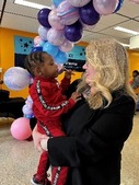 HRSA Administrator Carole Johnson with a toddler at the M.O.M.S. Tour Stop in Chicago