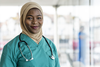 Black female nurse smiling in scrubs
