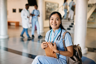 Nursing Student smiling while sitting with schoolbooks