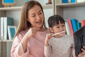 mother and daughter brushing teeth