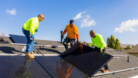 three men working on solar panel