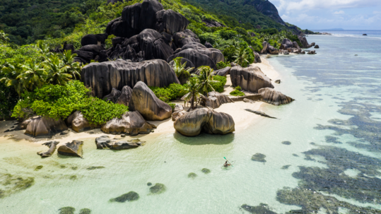 image of seychelles island with lone kayaker in water