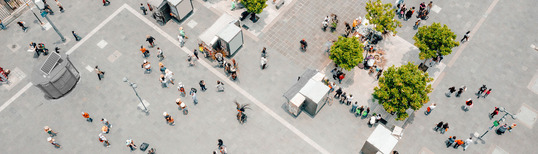 overhead image of people walking in a large plaza