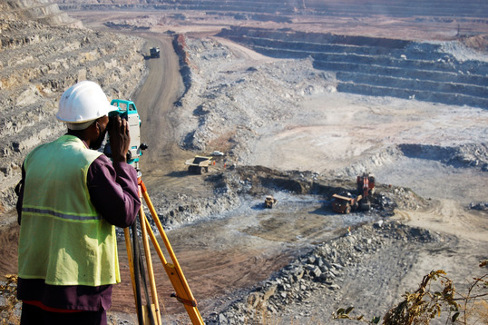 Construction worker using an instrument to analyze the mineral reserves