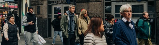 photo of people walking on street with focus on a couple